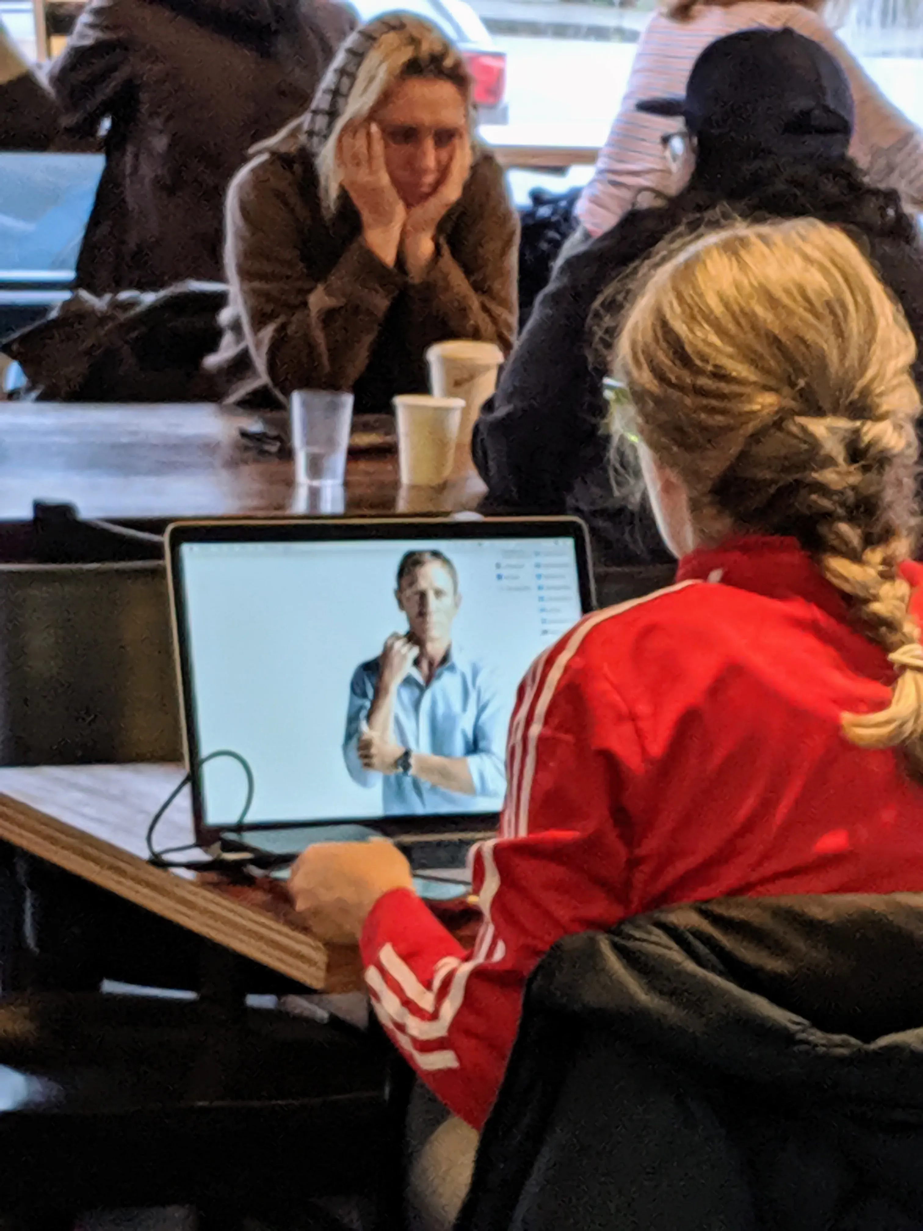 A computer in a café with a picture of Daniel Craig as the background